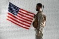 Side view of American soldier near national flag.