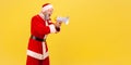 Side view of angry screaming elderly man with gray beard wearing santa claus costume holding megaphone and yelling with aggressive Royalty Free Stock Photo