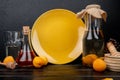 side view of apricot compote and peach syrup with apricots and garlic crusher on wooden surface and black background