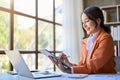 Side view of Asian businesswoman using her tablet to check her meeting schedule Royalty Free Stock Photo