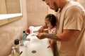 Man pouring toothpaste on toothbrush of daughter Royalty Free Stock Photo