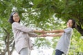 Side view of Asian mother and daughter holding hand and smile while standing in the park, Happy family concept Royalty Free Stock Photo