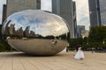 Side view of Asian wedding couple being photographed in front of the Cloud Gate Anish Kapoor sculpture, Chicago