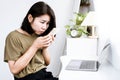 side view of Asian woman looking at a mobile phone with incorrect posture hunched back, forward head, and