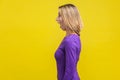 Side view of astonished beautiful woman looking left with stunned shocked face. isolated on yellow background Royalty Free Stock Photo