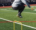 Side view of an athlete jumping over yellow mini hurdles Royalty Free Stock Photo