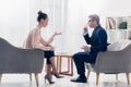 Side view of attractive journalist asking questions while businessman drinking coffee Royalty Free Stock Photo