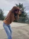 Side view of a attractive long haired and bearded young man photographer taking photo with DSLR camera while standing outside Royalty Free Stock Photo