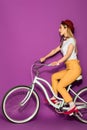 side view of attractive stylish asian girl riding bicycle and looking away Royalty Free Stock Photo