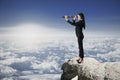 Side view of attractive young caucasian female with telescope standing on cliff and looking into the distance on bright blue sky Royalty Free Stock Photo