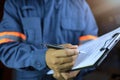 Side view, an auditor or specter holding a clipboard and checklist