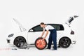side view of auto mechanic pushing tire to change old one