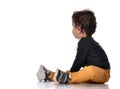 Side view of baby boy sitting on white background and turning away from camera. Royalty Free Stock Photo