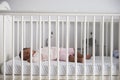 Side View Of Baby Girl Sleeping In Nursery Cot