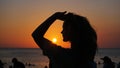 Side view of back light of a woman silhouette warm sunset in front of sun