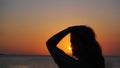 Side view of back light of a woman silhouette warm sunset in front of sun