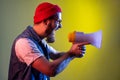 Side view of bearded hipster man yelling holding megaphone, looking to right side, protesting. Royalty Free Stock Photo