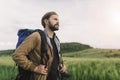 Side view of bearded photographer standing among green field