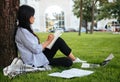 Side view of beautiful asian female student, studying in park, o Royalty Free Stock Photo