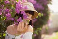Side view of beautiful girl in a white dress and straw hat in the blooming garden of cherry blossom Royalty Free Stock Photo