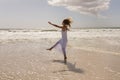 Beautiful happy young woman kicking water on beach Royalty Free Stock Photo