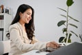 Side view of a beautiful Asian businesswoman working on her project on laptop Royalty Free Stock Photo