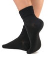 Side view of beautiful woman foot dressed in new nice and soft natural cotton fabric blank black socks Royalty Free Stock Photo