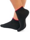 Side view of beautiful woman foot dressed in new nice and soft natural cotton fabric blank black socks with red edging Royalty Free Stock Photo