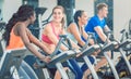 Side view of a beautiful woman smiling while cycling at the gym Royalty Free Stock Photo