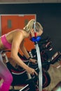 Female athlete with oxygen mask exercising with exercise bike in fitness studio