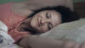 Side view of beautiful young Hispanic woman smiling while sleeping in her bed Royalty Free Stock Photo