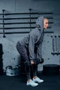 Side view of a beautiful young woman fitness instructor wearing a sports suit doing an exercise lunges with dumbbells on Royalty Free Stock Photo