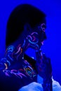 Side view on beautiful young woman with fluorescent prints on skin Royalty Free Stock Photo