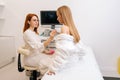 Side view of beautiful young woman getting breast examination during appointment at hospital. Female doctor using Royalty Free Stock Photo