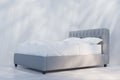 Side view of bed with white linen. Light and shadows on white wall Royalty Free Stock Photo