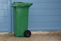 Side view big green trash can in street front home Royalty Free Stock Photo