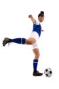 Side view of biracial young female soccer player kicking soccer ball while playing soccer Royalty Free Stock Photo