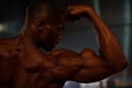 Side view of black african american fitness model showing muscles close-up in studio background Royalty Free Stock Photo