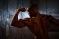 Side view of black african american fitness model showing muscles in studio background Royalty Free Stock Photo