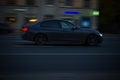Side view of black bmw 320d F30 model driving on the road. Night traffic scene