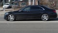 Side view of black Mercedes S-class car riding on the road on high speed. Shiny black sedan car in motion. Urban scene with riding Royalty Free Stock Photo