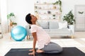 Side view of black pregnant woman doing backbend during meditation or yoga at home Royalty Free Stock Photo