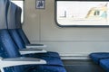 Side view of blue armchairs in empty train in row of three, no people in wagon,