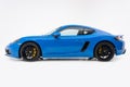 Shark Blue Porsche 718 Cayman GTS in studio, side view, white background, blue german sports car.