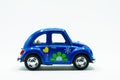 Side view of blue vintage car toy with colorful flowers paint Royalty Free Stock Photo