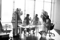 Side view of blurred silhouettes of businessmen talking in conference room