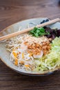 Side view of a bowl of Vietnamese shrimp and rice noodle salad with chopsticks