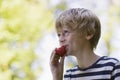 Side View Of Boy Eating Strawberry Outdoors Royalty Free Stock Photo