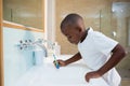 Side view of boy spitting in sink Royalty Free Stock Photo
