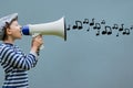 Side view of boy talking in megaphone with musical notes coming out Royalty Free Stock Photo